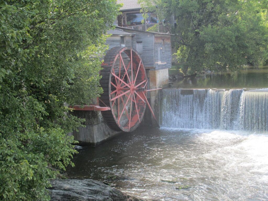 The red waterwheel of The Old Mill beside the dam on the Little Pigeon River in Pigeon Forge