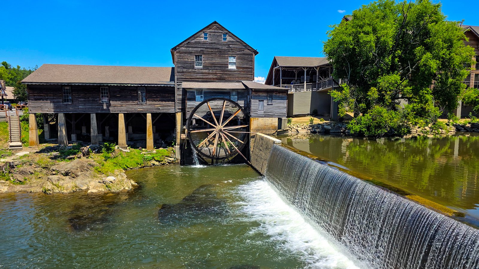 The historic Old Mill in Pigeon Forge with its wooden water wheel beside the dam on the Little Pigeon River
