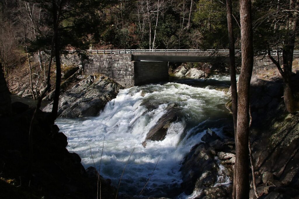 The Sinks waterfall rushing under the stone bridge on Little River Road in the Smokies
